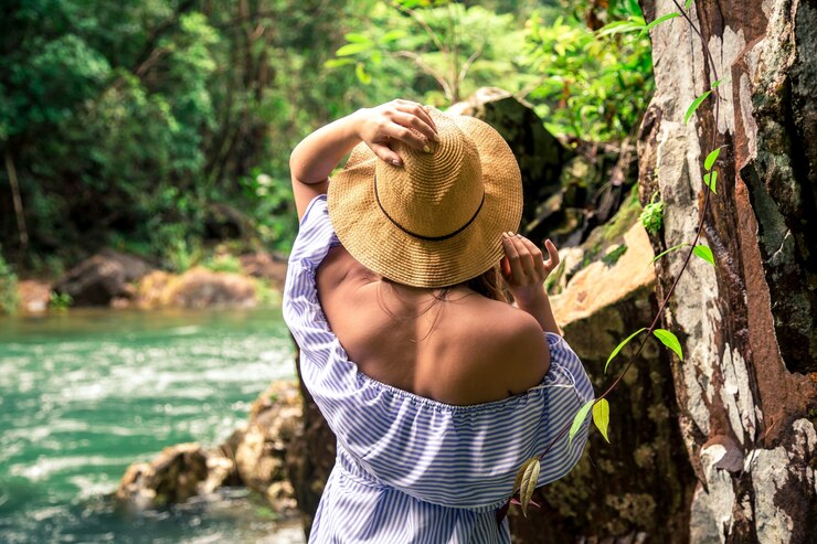 chica con sombrero en el río