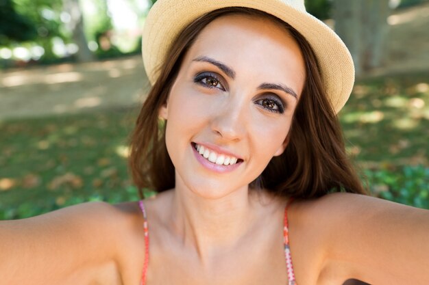 chica en el sombrero sonriendo mirando a la cámara