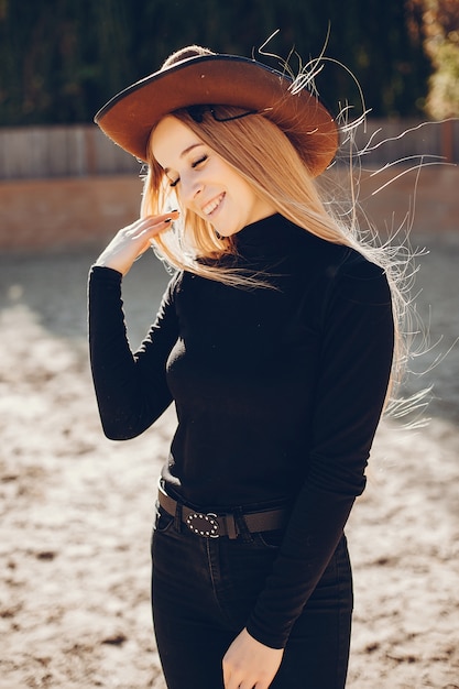 Chica en un sombrero de vaqueros en un rancho