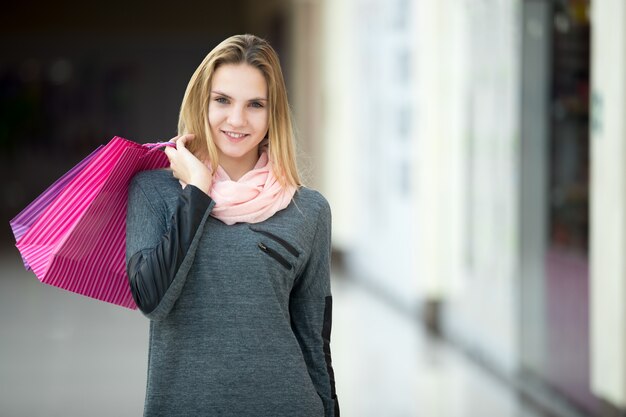 Chica sonriendo con una bolsa de la compra