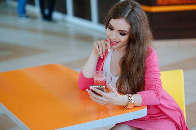 Chica sonriendo mientras mira su smartphone