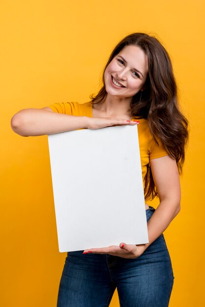 Chica sonriendo mostrando un cartel en blanco