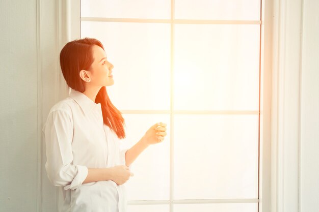 Chica sonriendo en una ventana