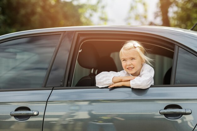 Chica sonriente de ángulo bajo en coche