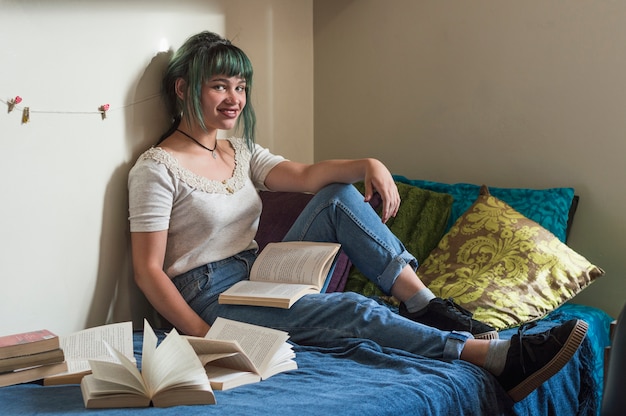 Chica sonriente estudiando en la cama