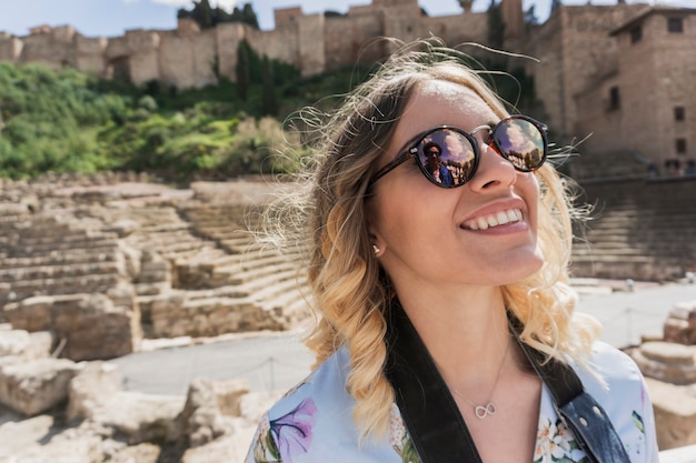 Chica sonriente en frente de un monumento