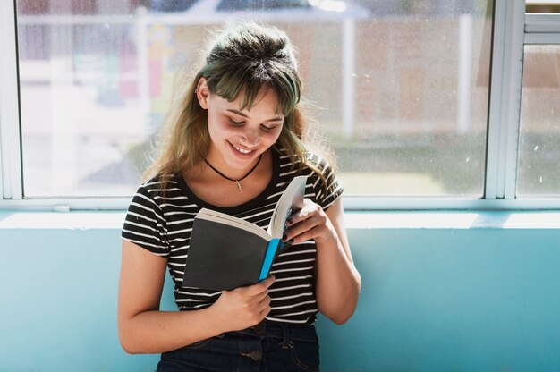 Chica sonriente leyendo en la escuela