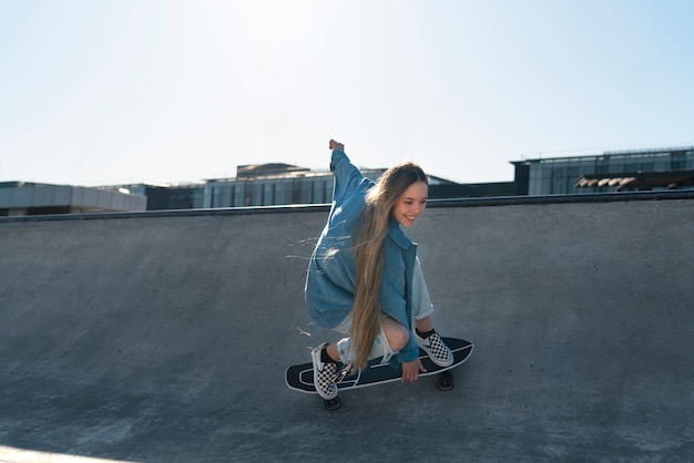 Chica sonriente en patineta al aire libre vista lateral