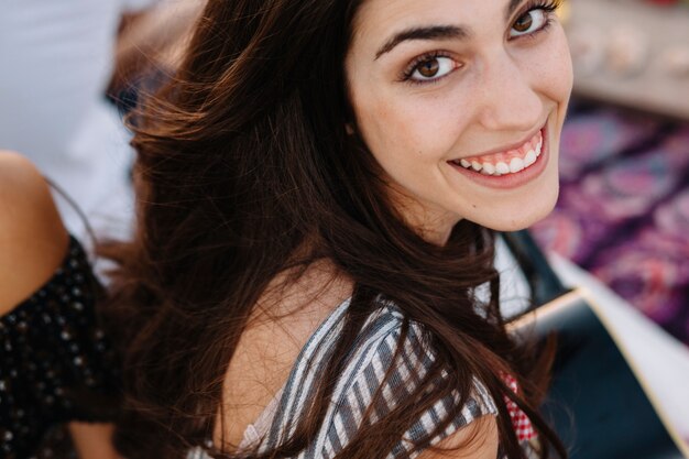 Chica sonriente por la playa vista de cerca