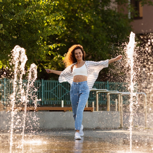 Chica sonriente posando rodeada de fuente