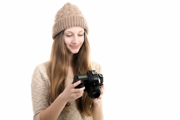 Chica sonriente revisando algunas fotos en su cámara