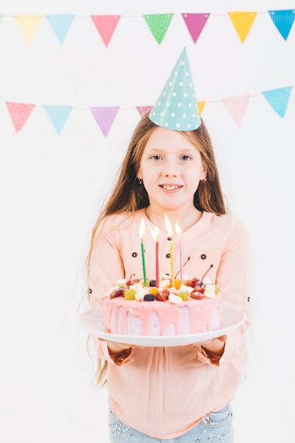 Chica sonriente con una tarta de cumpleaños