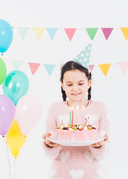 Chica sonriente con una tarta de cumpleaños