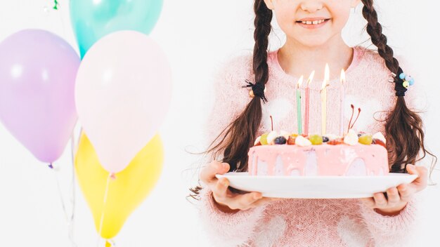 Chica sonriente con una tarta de cumpleaños