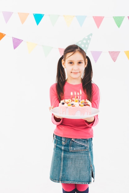 Chica sonriente con una tarta de cumpleaños