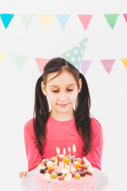 Chica sonriente con una tarta de cumpleaños