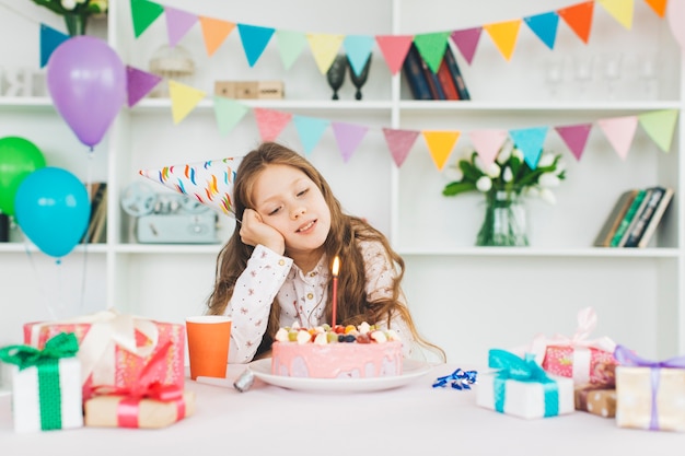 Chica sonriente con una tarta de cumpleaños