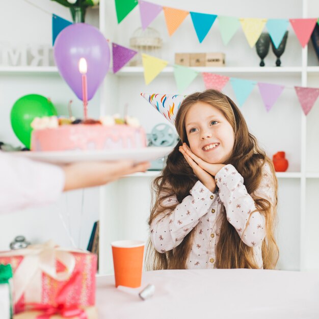 Chica sonriente con una tarta de cumpleaños