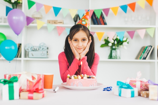 Chica sonriente con una tarta de cumpleaños