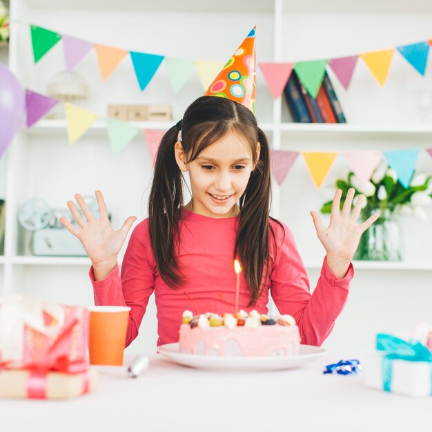 Chica sonriente con una tarta de cumpleaños