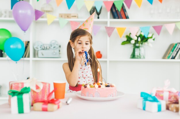 Chica sonriente con una tarta de cumpleaños