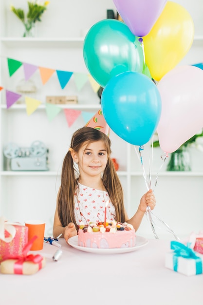 Chica sonriente con una tarta de cumpleaños