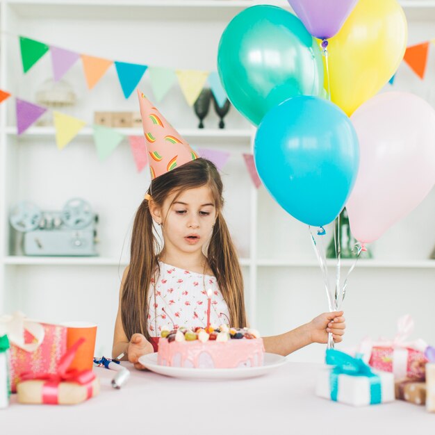 Chica sonriente con una tarta de cumpleaños