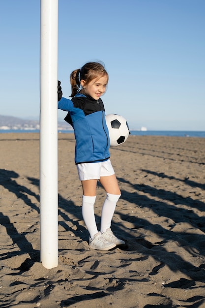 Chica sonriente de tiro completo con bola