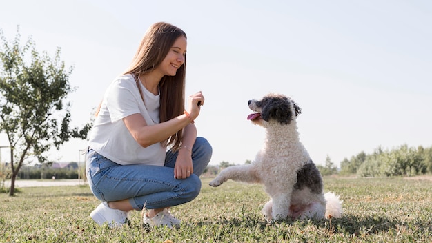 Chica sonriente de tiro completo con lindo perro