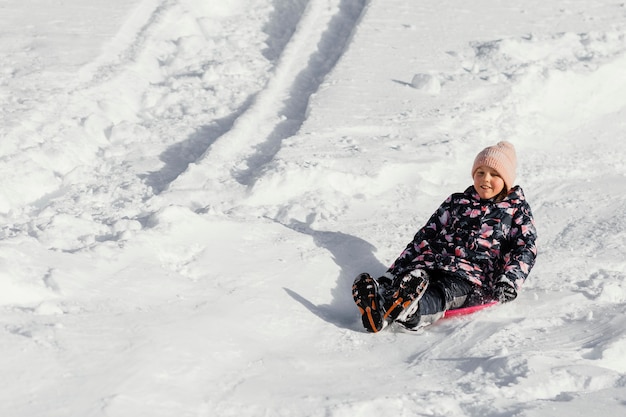 Foto gratuita chica sonriente de tiro completo en la nieve al aire libre