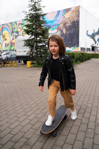 Foto gratuita chica sonriente de tiro completo en patineta