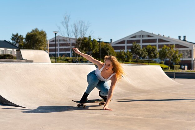 Chica sonriente de tiro completo en patineta