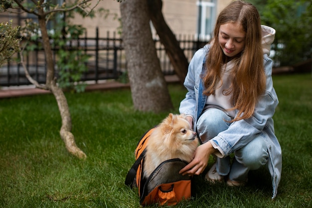 Chica sonriente de tiro completo con perro