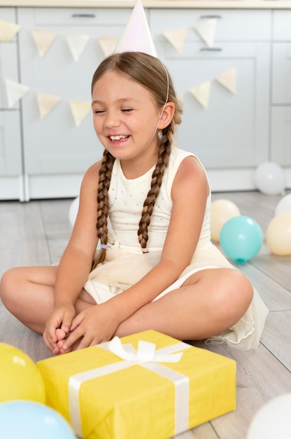 Chica sonriente de tiro completo en el piso