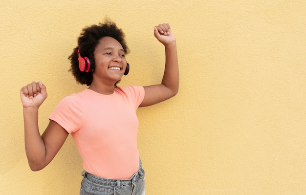 Chica sonriente de tiro medio con auriculares