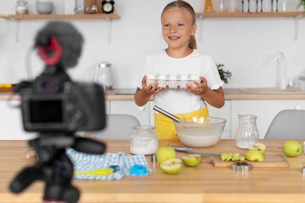 Chica sonriente de tiro medio cocinando