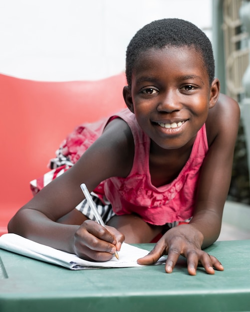 Foto gratuita chica sonriente de tiro medio escribiendo en un portátil