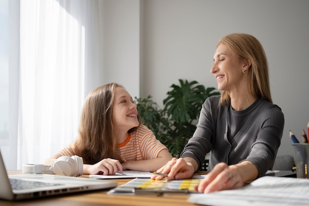 Foto gratuita chica sonriente de tiro medio y maestra en el interior