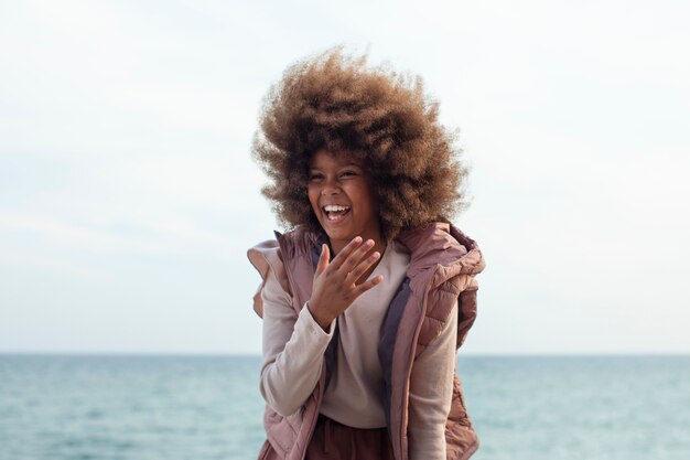 Chica sonriente de tiro medio en la playa