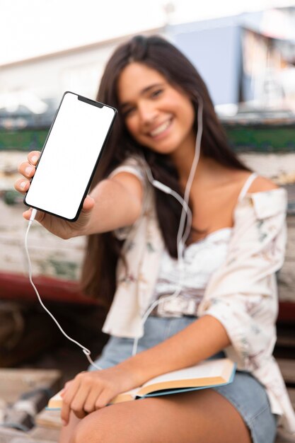 Chica sonriente de tiro medio con smartphone