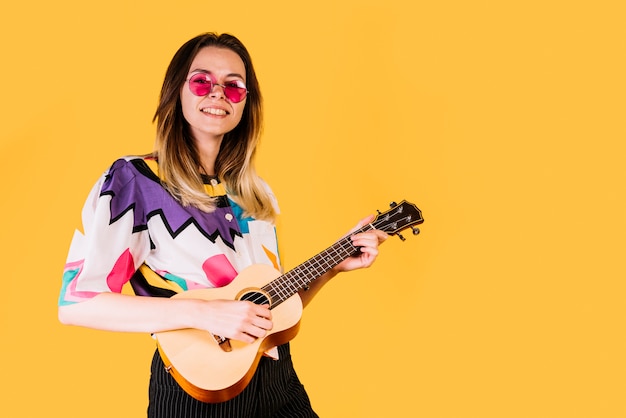 Foto gratuita chica sonriente tocando el ukelele