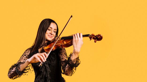 Chica sonriente tocando el violín