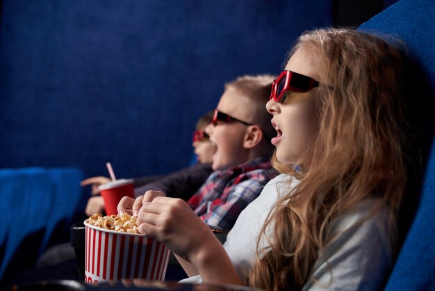 Chica sorprendida con amigos viendo películas en la sala de cine