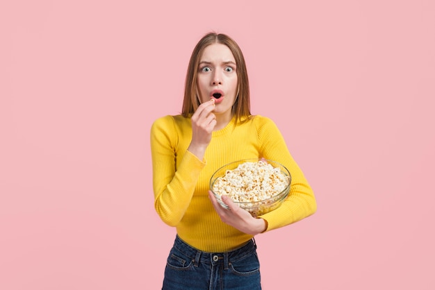 Chica sorprendida comiendo palomitas