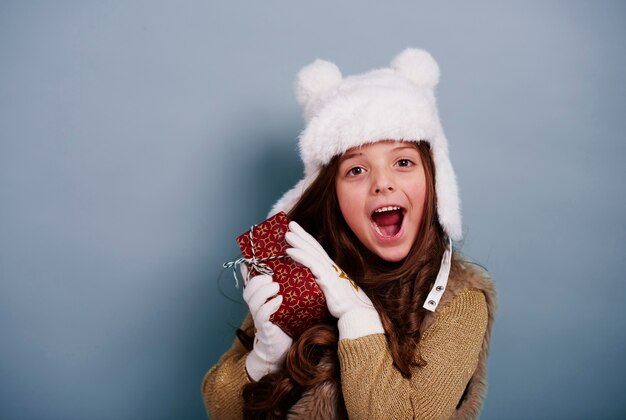 Chica sorprendida disfrutando con regalo de Navidad