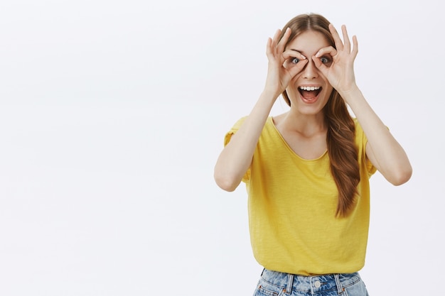 Foto gratuita chica sorprendida y emocionada mirando a través de gafas divertidas