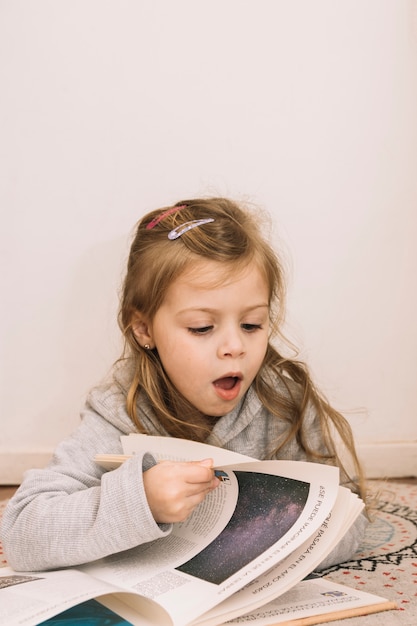 Chica sorprendida girando las páginas del libro