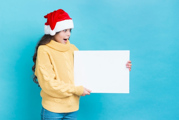 Foto gratuita chica sorprendida con maqueta de póster en manos