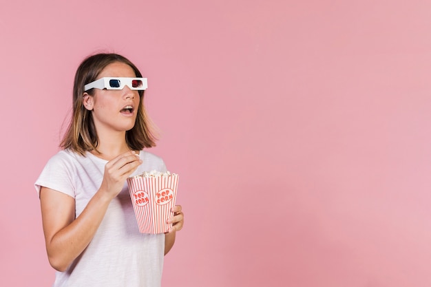 Chica sorprendida con palomitas y gafas 3d