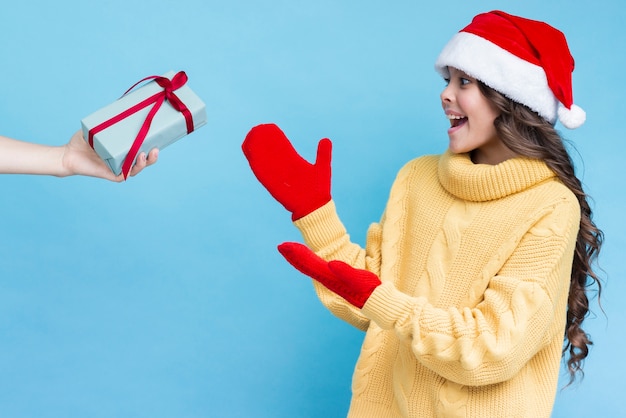 Chica sorprendida recibiendo regalo en invierno